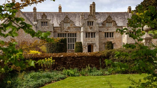 A leafy view of the front of the house at Trerice, taking from the road.
